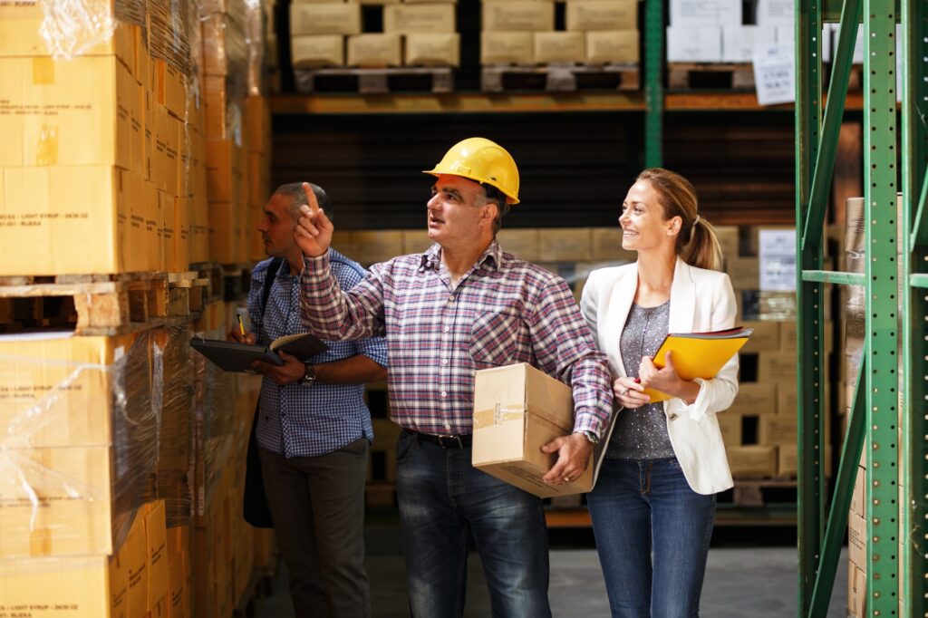 Szkolenie pracowników magazynu – instruktor omawia zasady bezpieczeństwa przy regałach